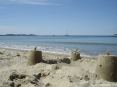 Cala Violina (GR) - La sabbia � fine e chiara. Un castello di sabbia con lo sfondo di Punta Ala, del suo porto e dello scoglio dello Sparviero