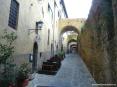 Castiglione della Pescaia (GR) - Via della Fortezza si arrampica sul colle tra antichi palazzi, archi e muri a sasso