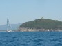 Gita in barca a Baratti, Piombino (LI) - Un barca a vela naviga verso il Golfo di Baratti con lo sfondo del promontorio settentrionale di Poggio del Molino e della Villa del Barone - Fotografia 8 luglio 2012, Toscana
