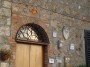 Montemassi, Roccastrada (GR) - Il portale di una abitazione circondato da antichi stemmi e frammenti di capitelli - Fotografia 8 dicembre 2011, Toscana