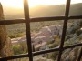 Montemassi, Roccastrada (GR) - La luce del sole al tramonto scalda la vista del paese attraverso una grata della torre del castello con lo sfondo della campagna maremmana coltivata ad ulivi - Fotografia 8 dicembre 2011, Toscana