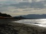 Spiaggia di Carbonifera, Piombino (LI) - Foto del bagnasciuga della spiaggia attrezzata con lettini e ombrelloni. Al centro si riconosce la sagoma dell