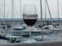 Tutti pazzi per la palamita 2013 - Un calice di vino rosso della Val di Cornia con lo sfondo delle barche ormeggiate nel porto - San Vincenzo (LI), Fotografia 5 maggio 2013, Toscana